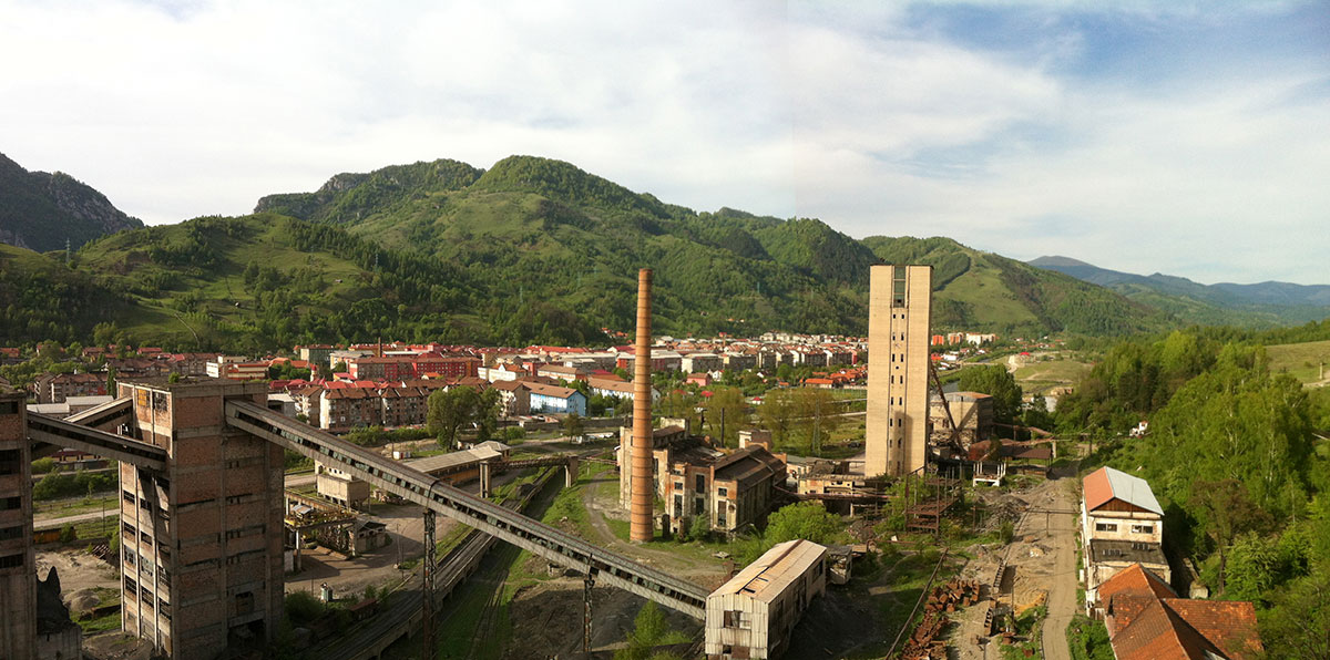 Imaginea panoramica Vedere din Puțul central spre oraș (clădirile minei surpinse în imagine: stația unghiulară, compresoarele vechi, puțul vechi, ateliere, magazii)