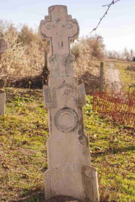 Fig. 41 Cruce de secol XIX, cimitirul parohial Greceanca, Buzău. De o mai mare încărcătură simbolică, acest monument conţine elementul asemănător crucii de la Ştefăneşti - Pomul sau Floarea vieţii (Fig. 24), căruia i se adaugă Crucea-Arbore, pe care este răstignit Iisus; un element vegetal, poate un snop de grâu, se află la baza crucii de sus, iar Cununa recunoaşterii virtuţilor, a vietii veşnice este plasată sub Floarea vieţii. Deşi aflate în judeţe diferite (Călăraşi şi Buzău), ambele monumente (Fig. 23-24) au comun până şi ediculul de deasupra motivului vegetal.