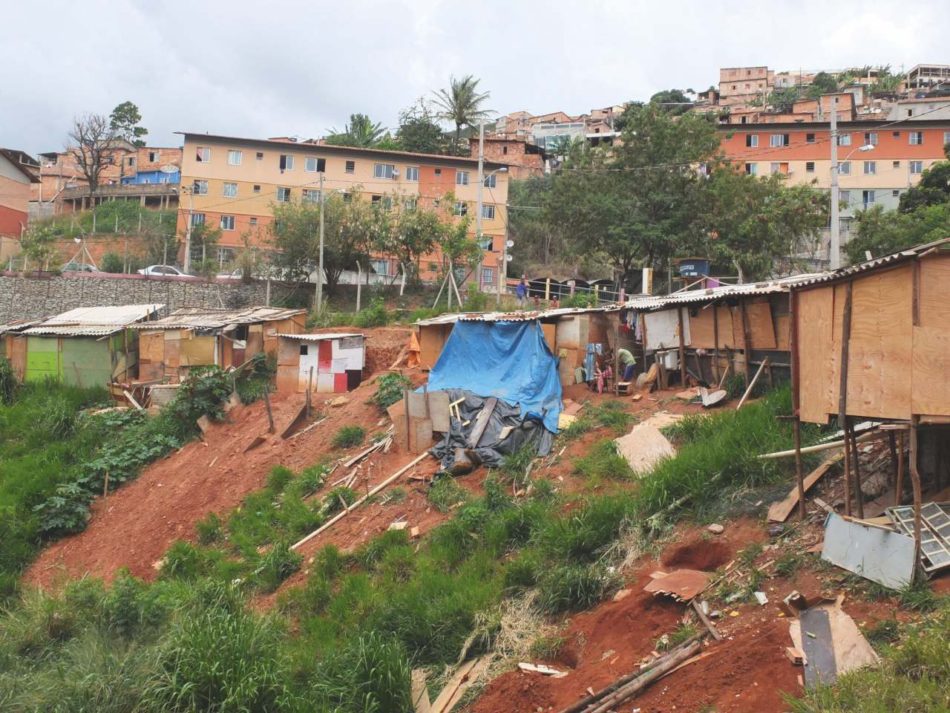Ansambluri de locuințe construite prin programul național MCMV în Aglomerado da Serra. În plan îndepărtat se observă așezarea informală construită de-a lungul timpului, iar în plan apropiat o ocupare recentă de teren de către noii rezidenți ilegali.